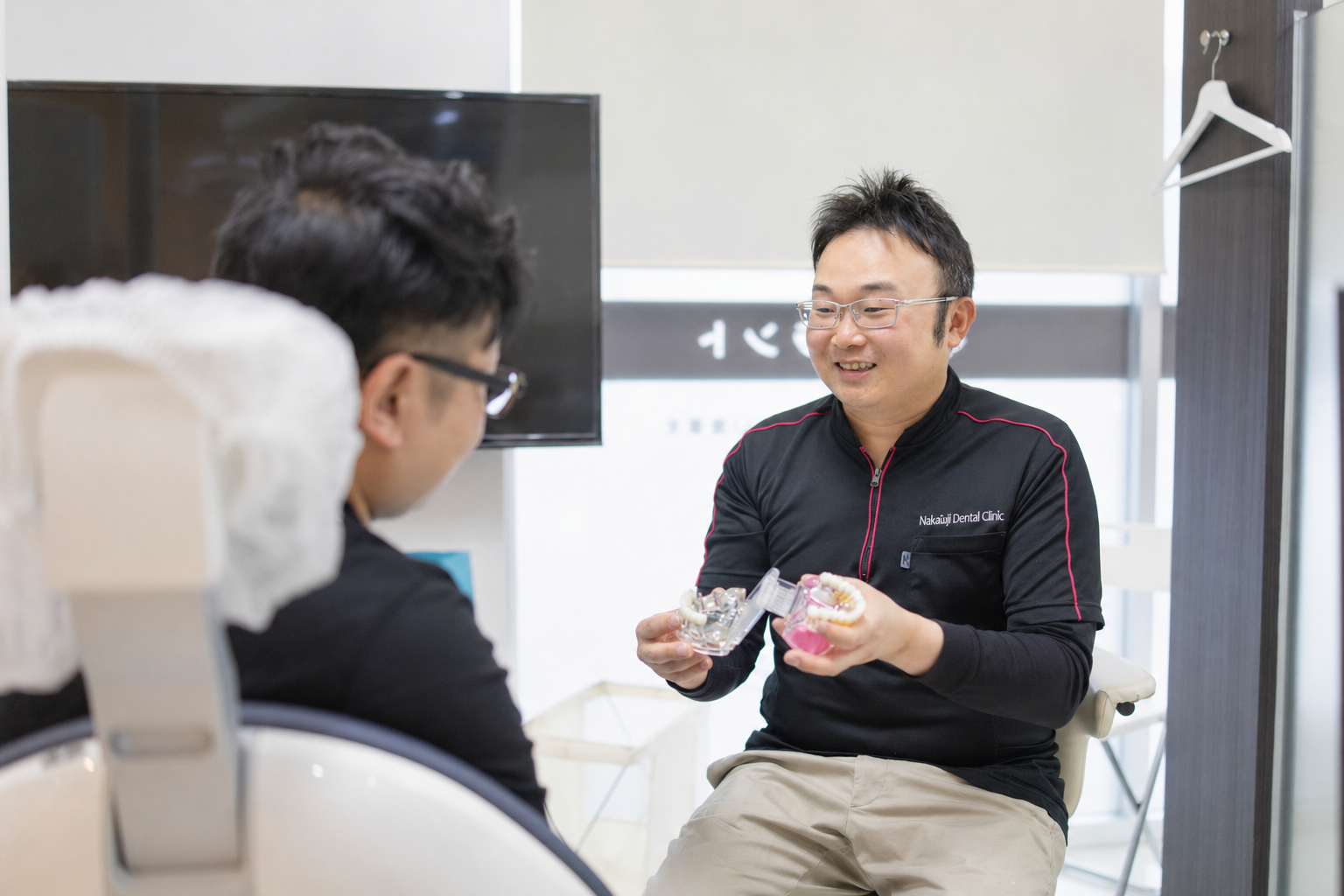 院長が患者の口元を真剣に診察している様子