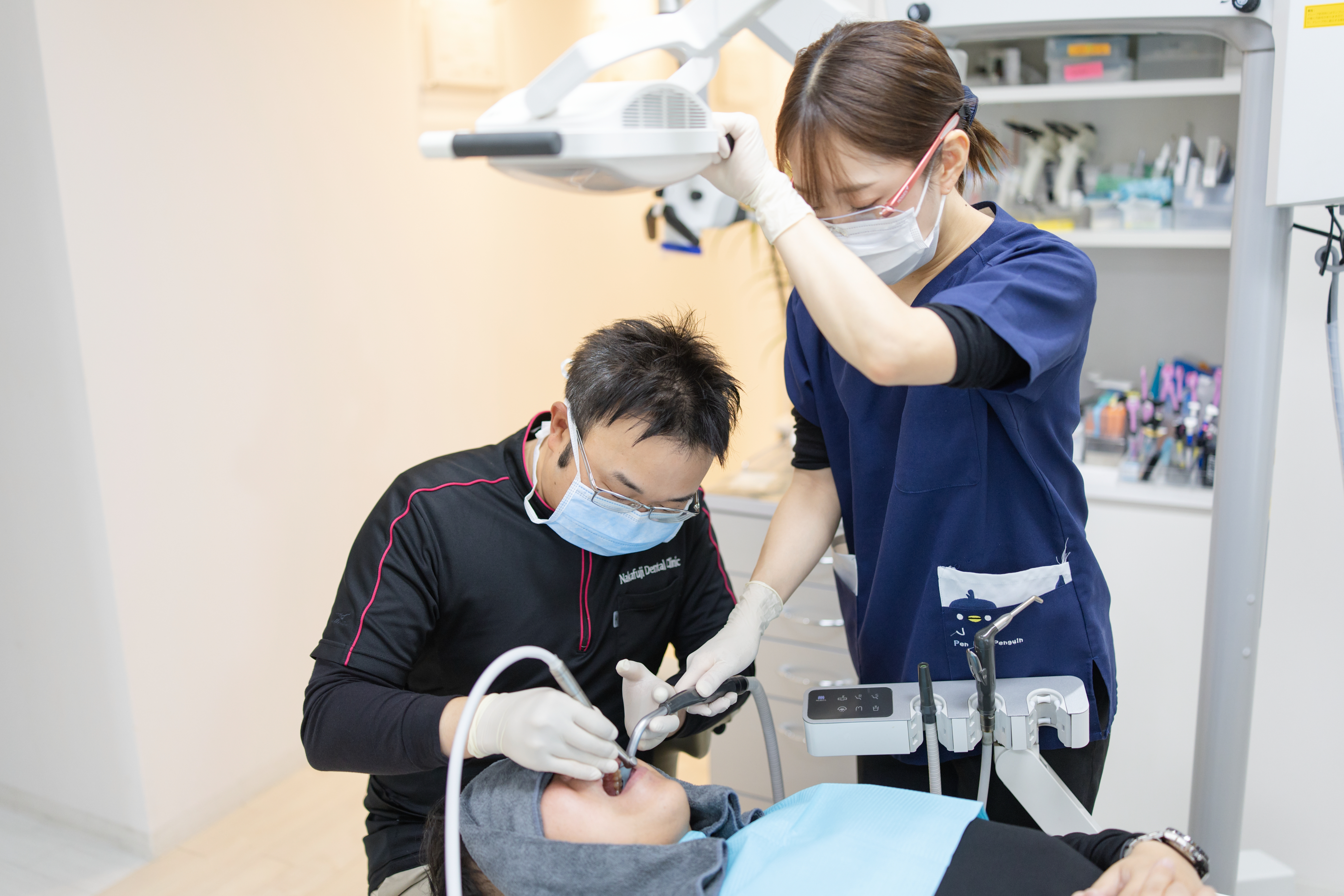 歯科医師とアシスタントが連携して患者の歯を治療する様子