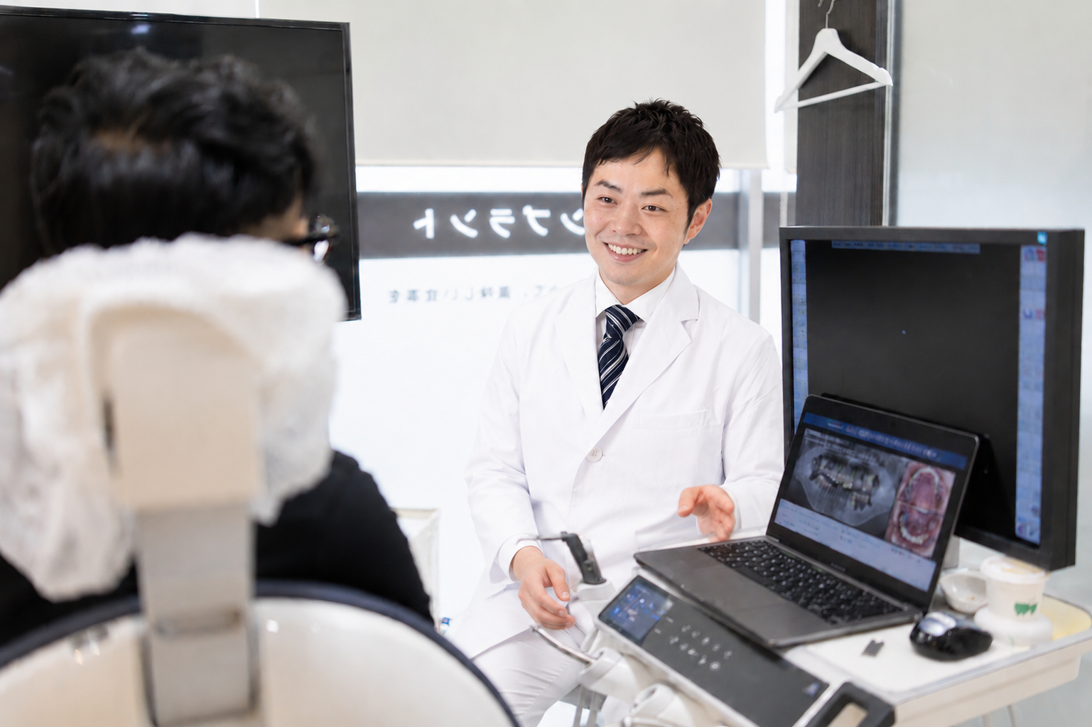 レントゲンを見せながら笑顔で矯正治療を説明する矯正担当医